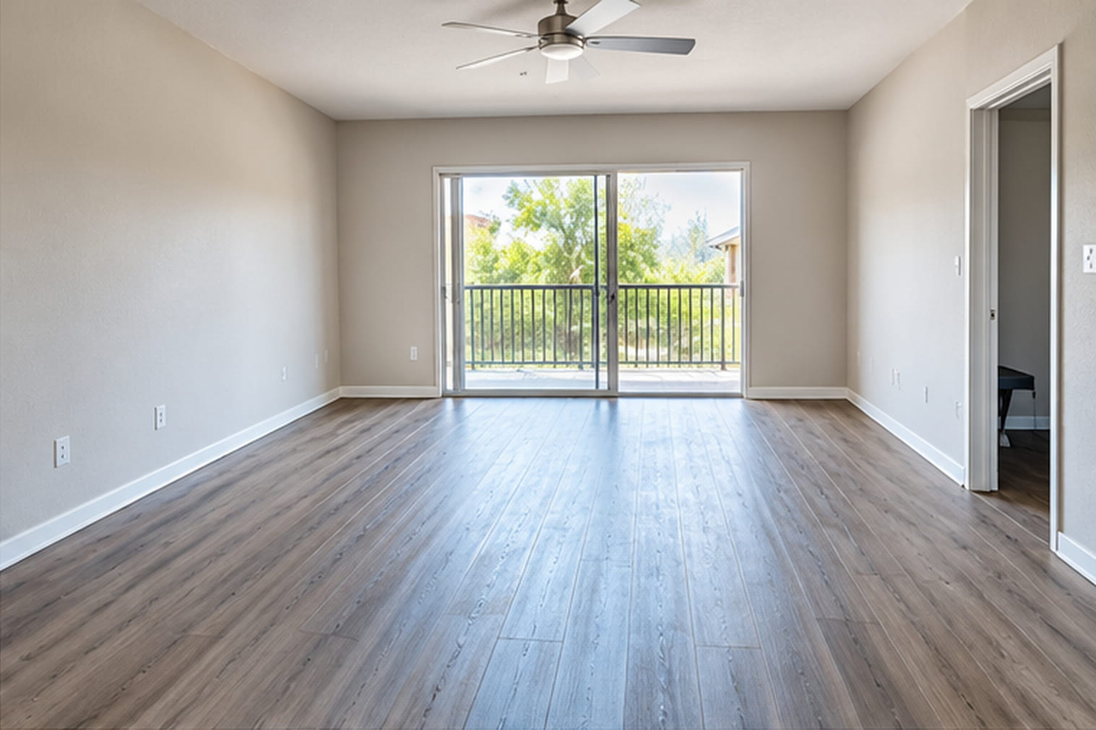Empty, fully cleaned apartment room with wood flooring after junk removal